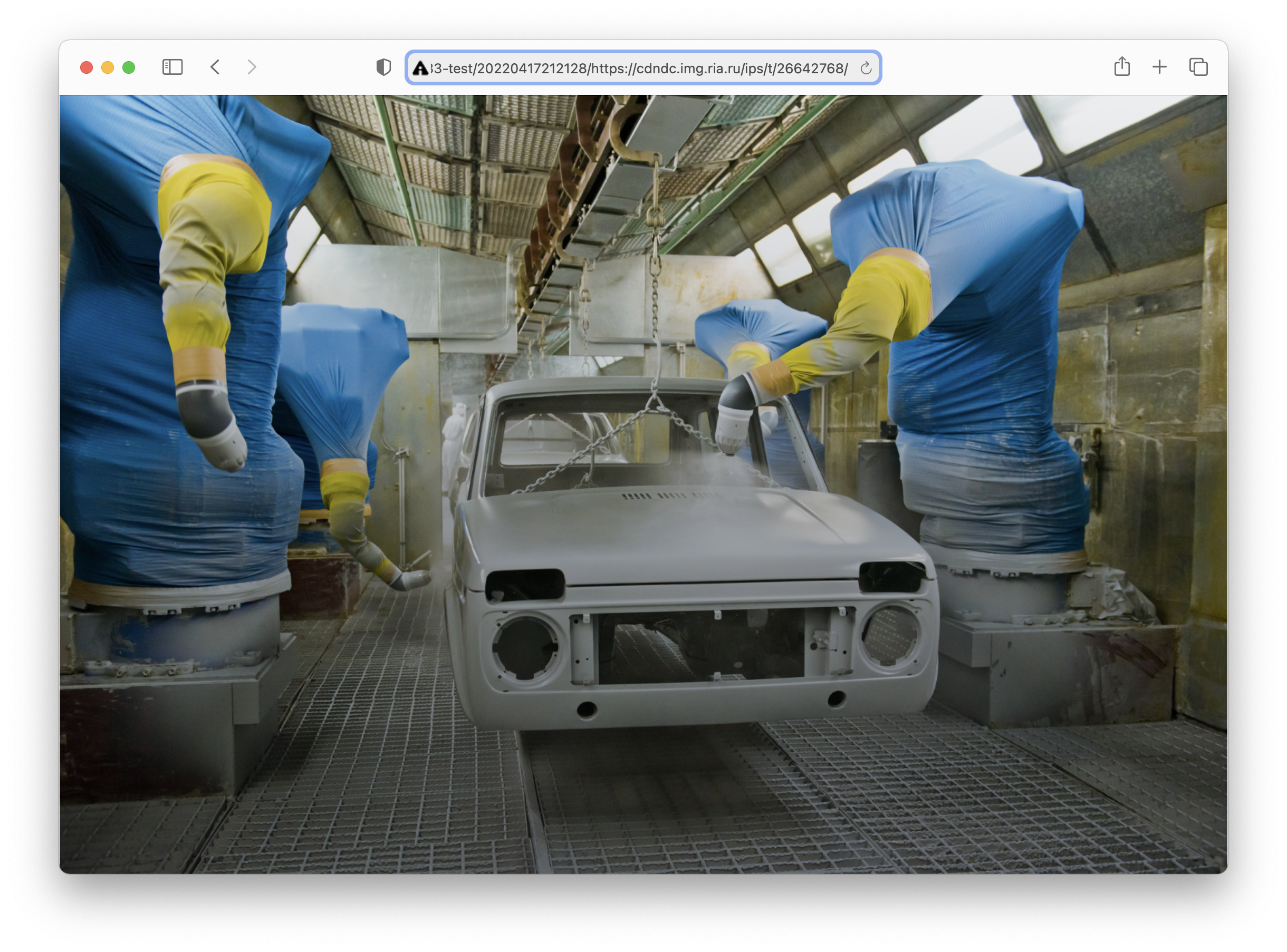 Photograph of robots wrapped in Ukrainian flags painting a Lada car